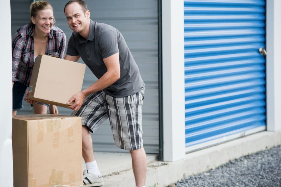 a couple moving their items into a storage unit